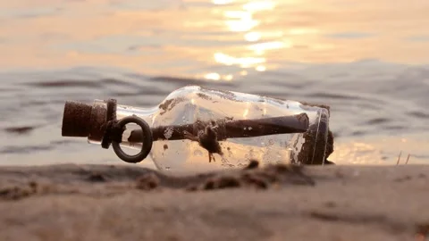 Message in the bottle against the Sun setting down Stock Footage 137127180
