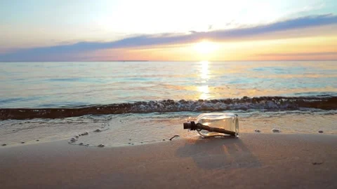 Message in the bottle against the Sun setting down Stock Footage 161499913