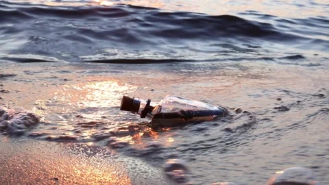 Message in the bottle against the Sun setting down Stock Footage 199634845
