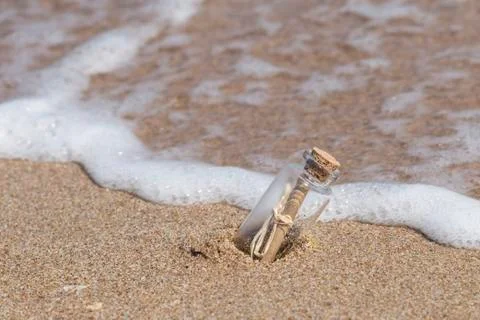 Message in a bottle on beach Stock Photos