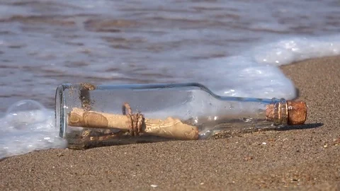 Message in bottle rolling on the sand, vacation on beach Stock Footage 80601845