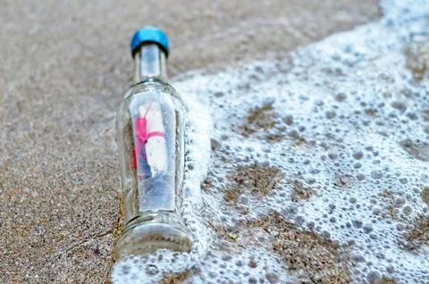 Message in the bottle on sandy beach Stock Photos