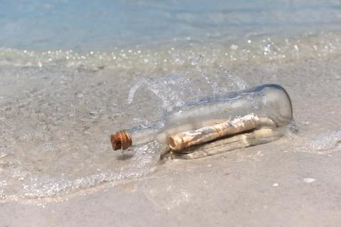 Message in a bottle on shore Stock Photos