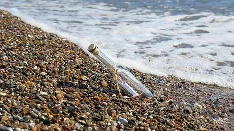 Message in a bottle, stranded bottle on the beach, slow motion Video stock 90523370