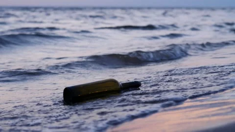 Message in a bottle washed up on the beach by the waves Stock Footage 314251672
