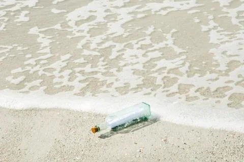 Message in a bottle washed up on shore Stock Photos