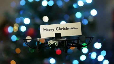 Message delivery by drone : season's greetings with christmas tree bokeh Stock Footage 99547845