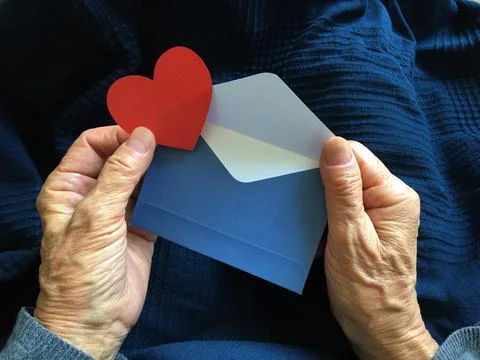 A message in an envelope in the hands of an elderly lady Stock Photos