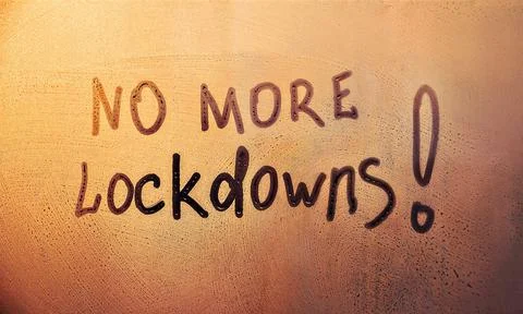 Message, No more lockdowns are painted handwriting on wet orange glass of sunset Stock Photos
