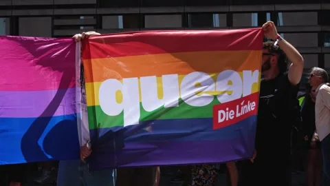 Message "queer" on a LGBTQ+ rainbow flag from the political party "Die Linke" Stock Footage 344753164