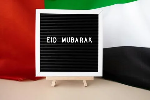 Message text EID MUBARAK - happy holidays waving UAE flag on background concept Stock Photos