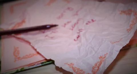 A message is written on the torn, crumpled sheet. Stock Photos