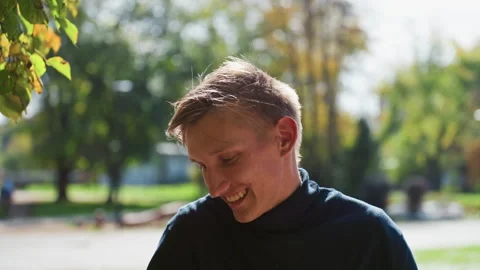 Messenger with backpack enjoying sunshine, Young man carrying parcel in park Video stock 329575222