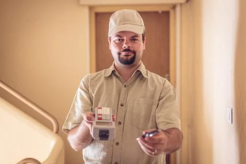 Messenger Delivering A Parcel, Asking For Your Signature Stockfoto's