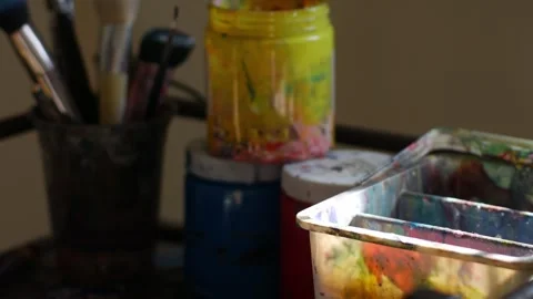 Messy artist studio table with acrylic paint brushes Stock Footage 340449866