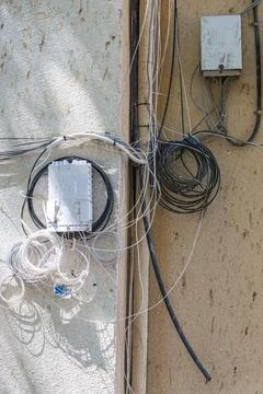 Messy cables and wires on building wall Stock Photos