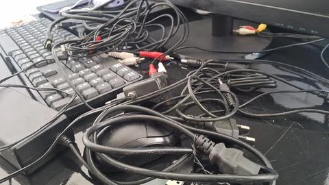 Messy computer cables on a desk. Tangled wires and electronic equipment on a Stock Photos