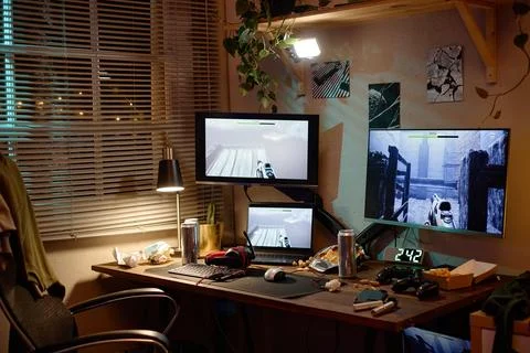 Messy Computer Gaming Desk Setup with Multiple Screens at Night 写真素材