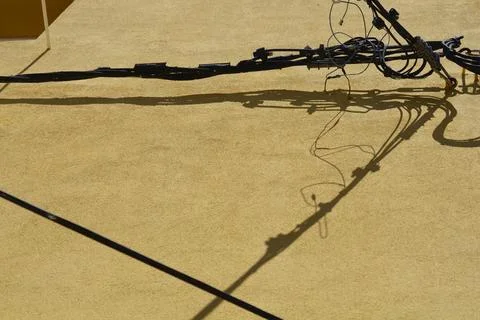 Messy electrical cables bundle on house facade with harsh shadows Stock Photos