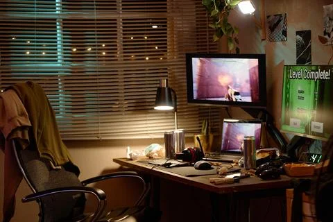 Messy Gaming Room with Computer Screens Showing Video Game Stock Photos