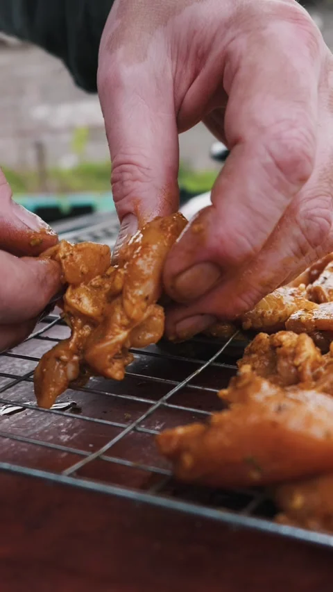 Messy Hands Placing Raw Marinated Chicken on Grill Rack for Bbq Vidéo 334123756