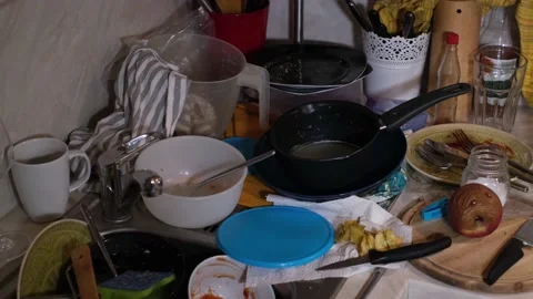 Messy kitchen. Colorful dirty plates, bowls, metal pots, mugs and cutlery Stock Footage