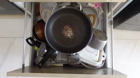Messy kitchen drawer with various cooking utensils and pans 動画素材 309906245