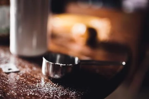 Messy kitchen table top with measuring cup and granules of sugar Foto stock