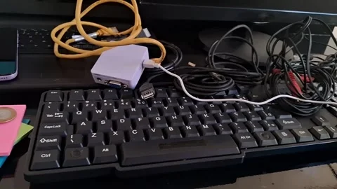 Messy office desk with computer gear. Cluttered workspace with keyboard, coins Stock Footage 340241506
