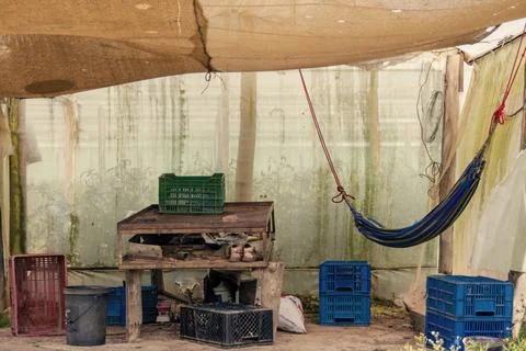 A messy rustic shack  made out of plastic, with a wooden rickety table and a  Foto stock