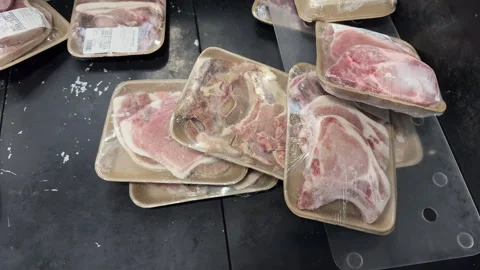 Messy Stack of Packaged Pork Chops in Supermarket Meat Case Stock Footage 337982664