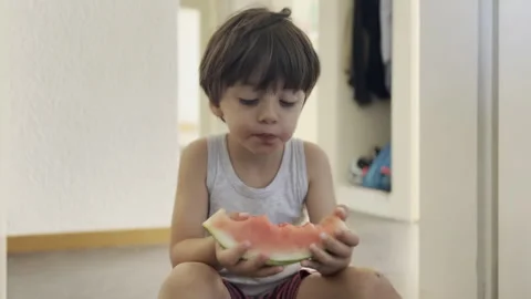 Messy Summertime - Carefree Boy Devours Watermelon on the Floor at Home, Fr.. Stock Footage 253119936
