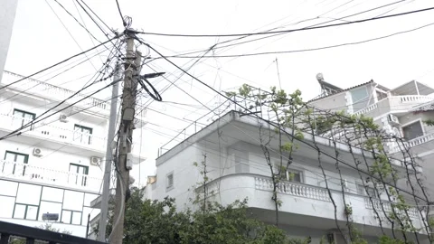 Messy Tangle of Overhead Power and Utility Lines on Street Utility Pole in Stock Footage 344278481