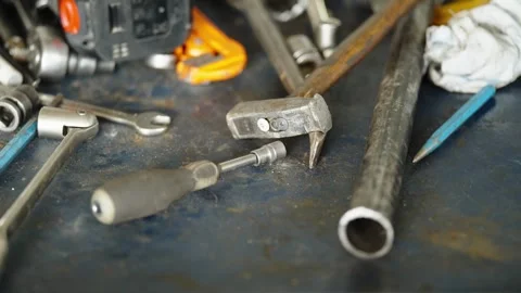 A messy workbench with various mechanical hand tools including a hammer Stock Footage 337890086