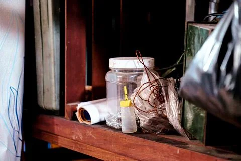 Messy workshop bench with tools, supplies, and tangled wires in a dusty setting Stock Photos