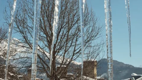 Mestia Georgia view through icicles with Svan towers and snowy mountains in.. Stock Footage 311873760