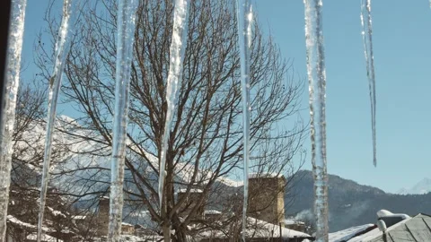 Mestia Georgia view through icicles with Svan towers and snowy mountains in.. Stock Footage 315492161