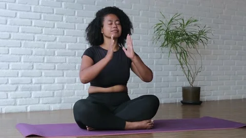 Mestizo practices yoga in a spacious bright room on a mat, develops flexibility Stock Footage 197904421