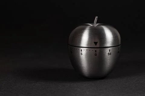 Metal apple kitchen timer on dark background Stock Photos