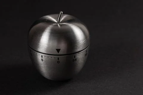 Metal apple kitchen timer on dark background Stock Photos