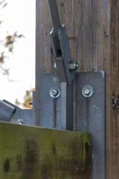 A metal attachment point for a diagonal pipe to a wooden beam. Foto stock