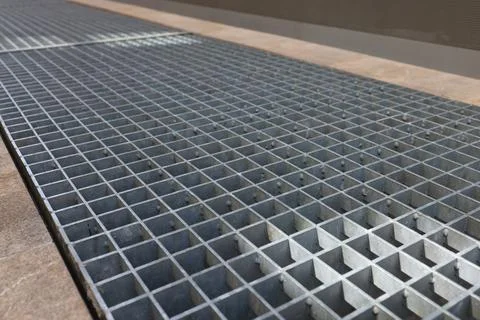 Metal bar grating over technical channel in marble floor Foto stock