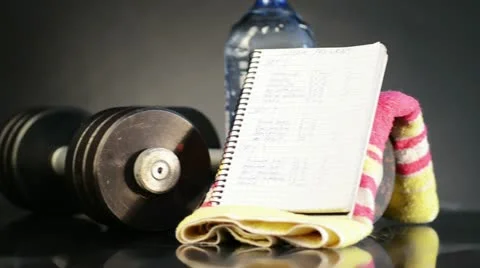 Metal barbell with week program and water Stock Footage 11848090