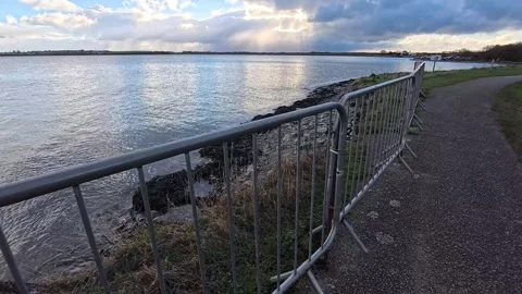 Metal barrier security gates warning public of recent coastal erosion Stock Footage 325660340