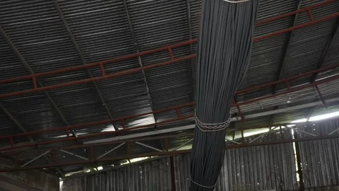 Metal bars are hoisted from a truck by thick chains, illustrating logistics at a Vídeo Stock 312781663