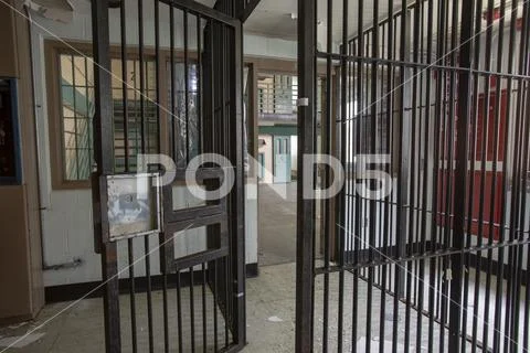 Metal bars leading into cellblock in prison Stock Photos