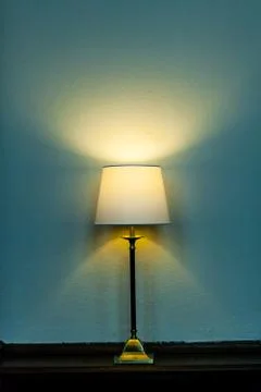 Metal base table lamp lighted lying wooden furniture. Luminous stand chandelier Stock Photos