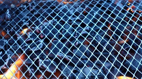 Metal bbq grill grate with burning charcoal, fire flames, and smoke Stock Footage 337538920