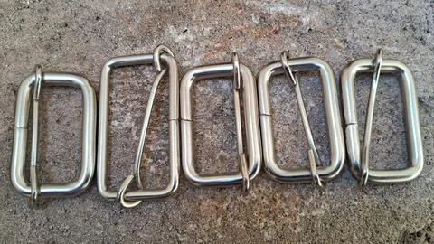 Metal belt buckles in a row. Silver rectangular hardware fasteners for leather Stock Photos