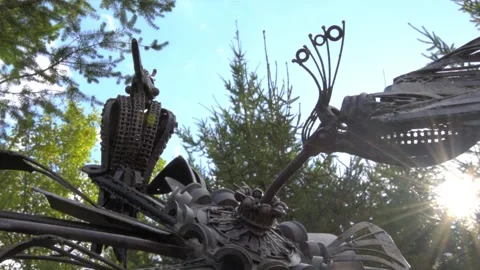 Metal bird sculpture in front of trees, tilt up, Full HD 1080 Stock Footage